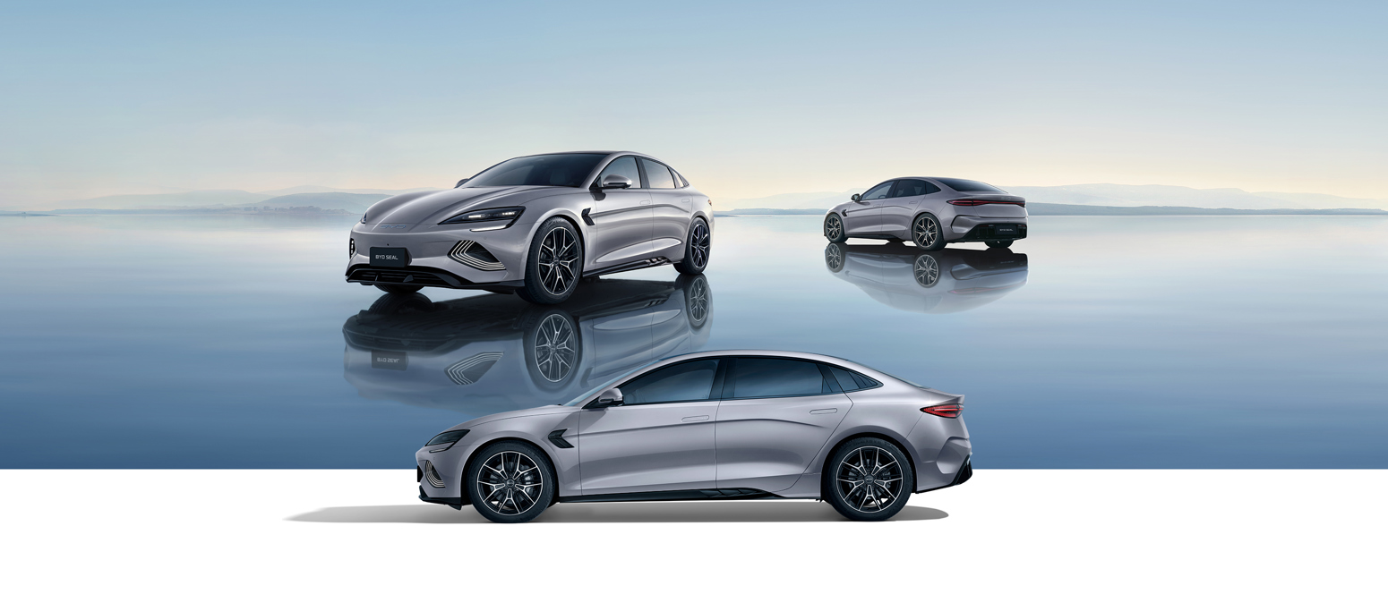 Tre sølvfarvede sedaner vises på en reflekterende overflade under en klar himmel, hvor man kan se bilen forfra, bagfra og fra siden.