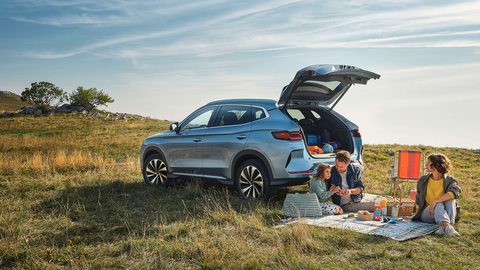 Familie holder picnic ved siden af BYD SEAL U med åbent bagagerum