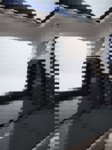 Et moderne bilinteriør med fokus på de forreste passager- og førersæder, med detaljerede syninger og synlige kontrolpaneler.