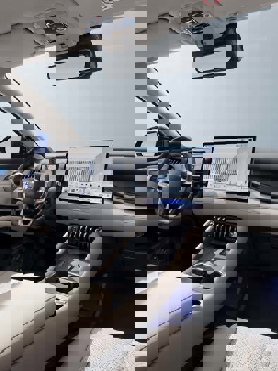 Et bilinteriør med instrumentbræt, rat, midterkonsol og en digital skærm.