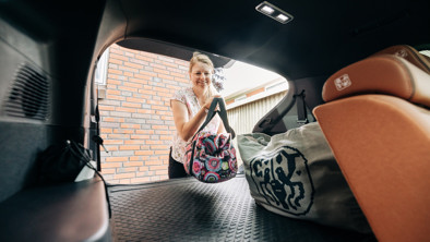 Kvinde placerer tasker i bagagerummet i BYD TANG