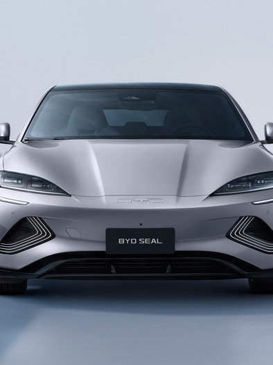 En sølvfarvet BYD Seal-elbil vises forfra i et minimalt, godt oplyst studie.