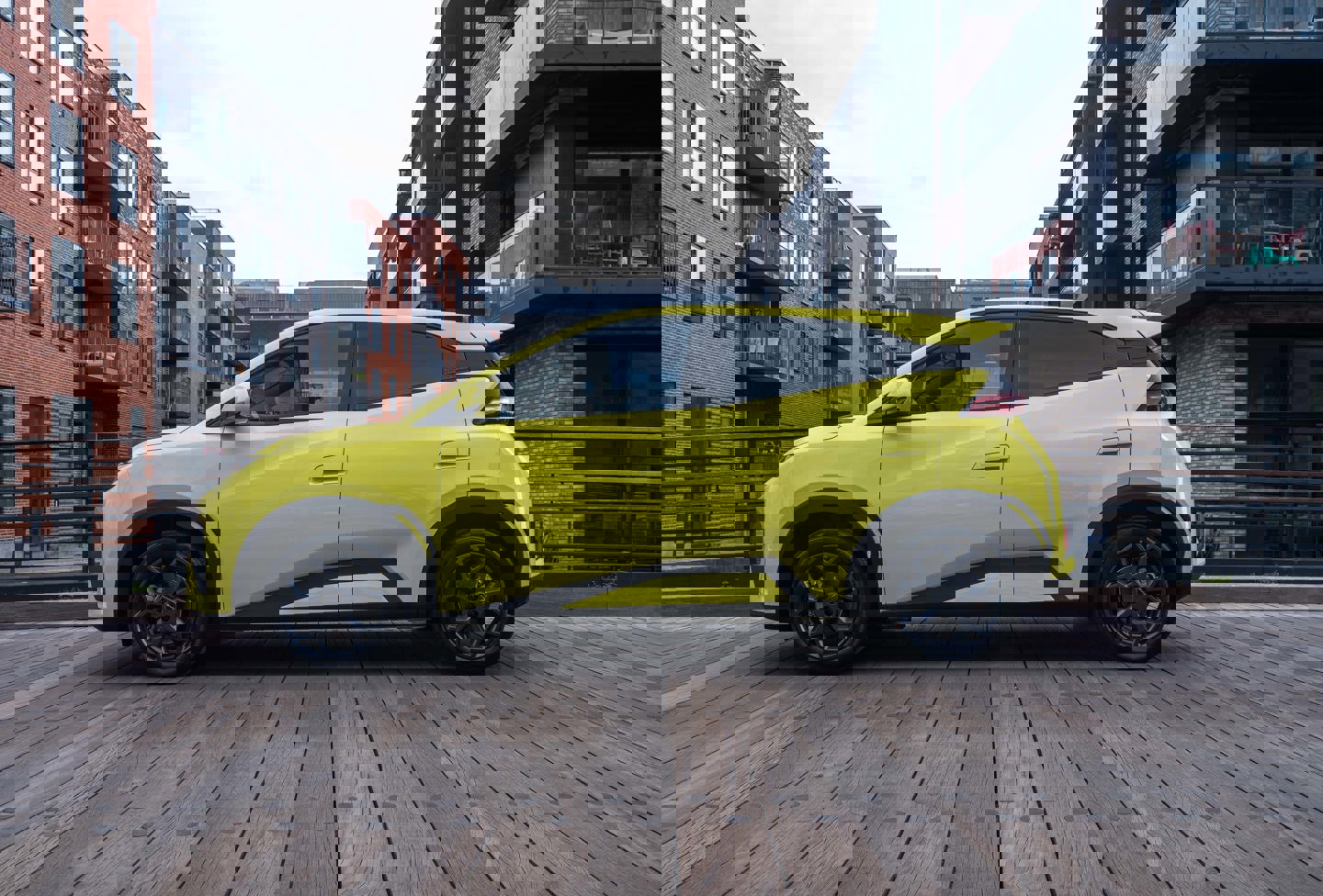 En bygade med høje bygninger og biler, set fra bagsiden af en parkeret bil.