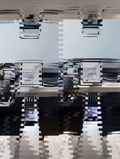 Interiøret i en moderne bil med to forsæder, et instrumentbræt, et rat og en midterkonsol.