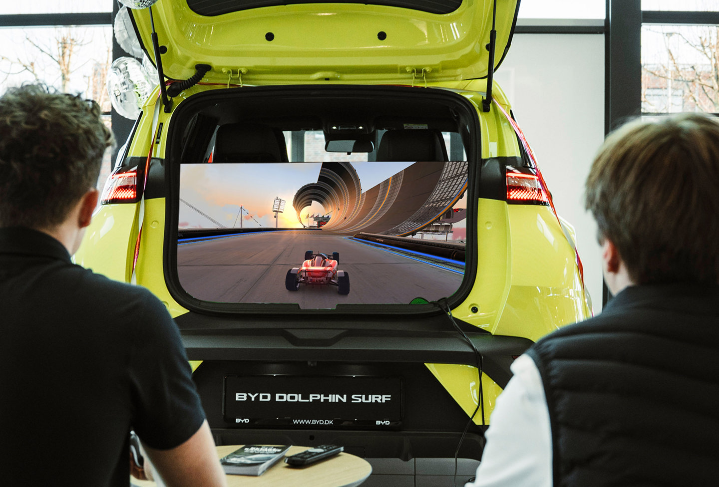 To personer spiller PlayStation fra bagagerummet i BYD