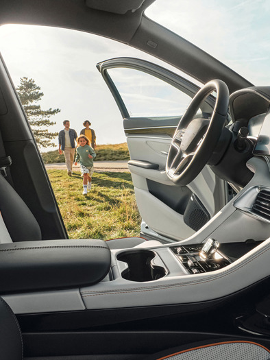 Familie løber hen mod åben bildør i BYD SEAL U