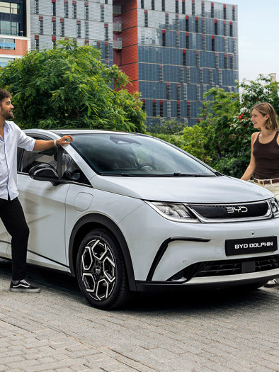 Mand og kvinde der står ved en BYD DOLPHIN