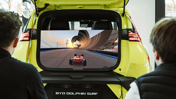 To personer spiller PlayStation fra bagagerummet i BYD